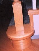 Photo of the bottom of a stairway newel post.